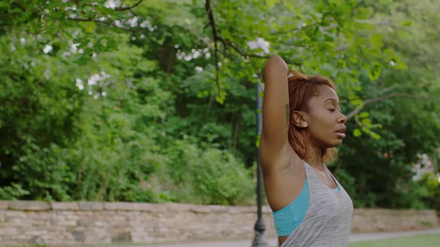 A woman stretches in a park