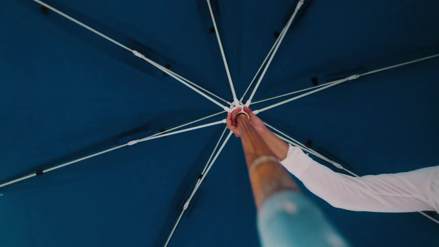 A woman opens up her umbrella
