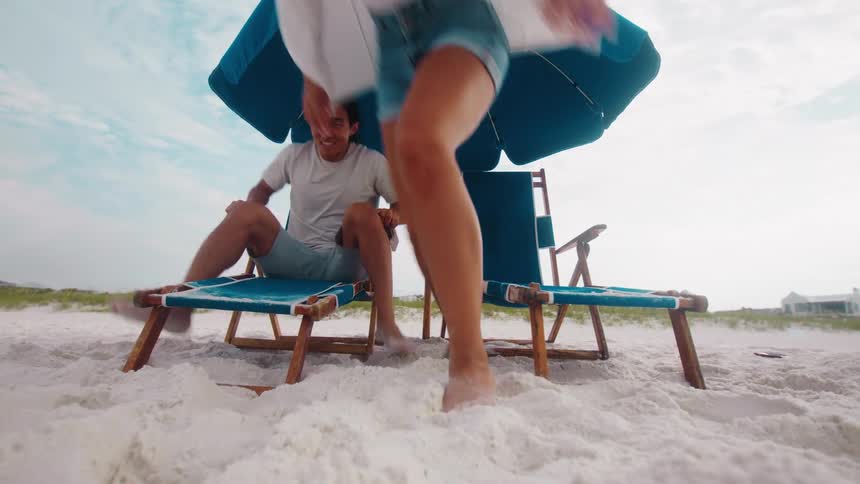 Two vacationers run on the beach