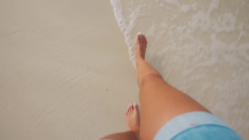 Person walking barefoot on wet sand