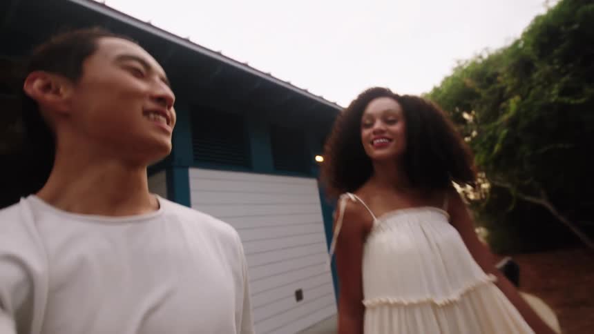 A man and woman talk and walk outside