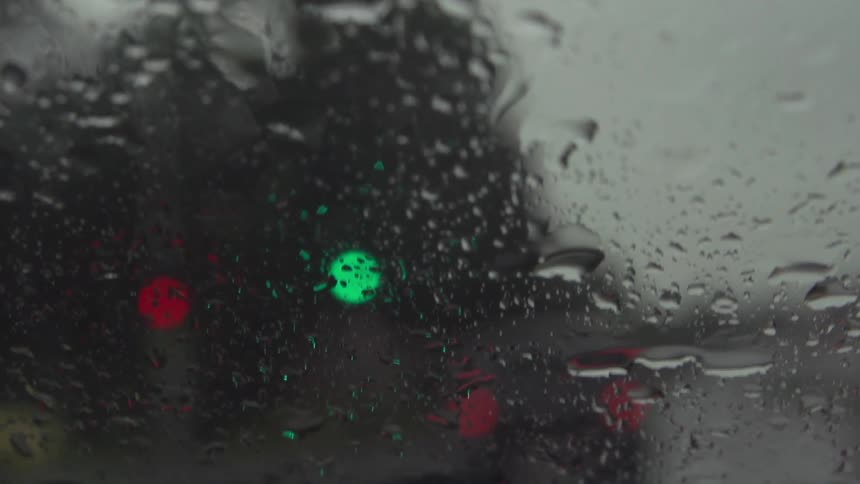 Rain falls on a car windshield