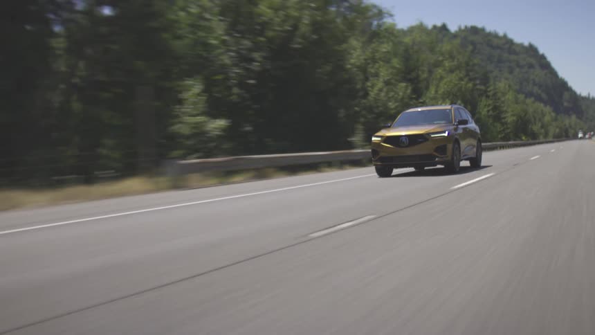 A yellow suv is driving down a tree lined freeway