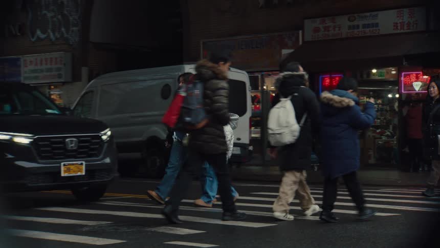 Mother and daughter cross a busy city street talking