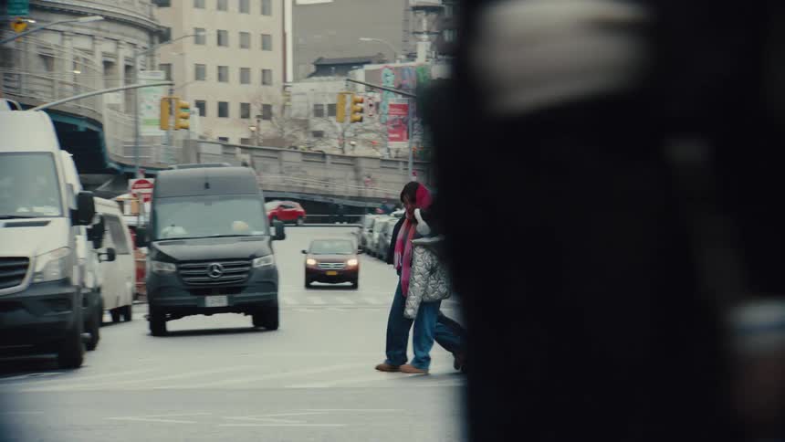 Adult person with a child crossing a street and an urban road