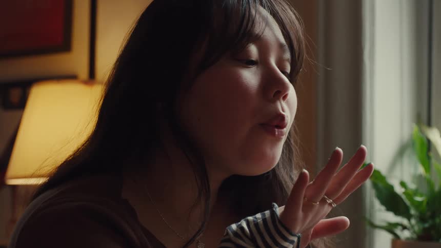 Teenage girl with a ring on her finger blowing on her hand