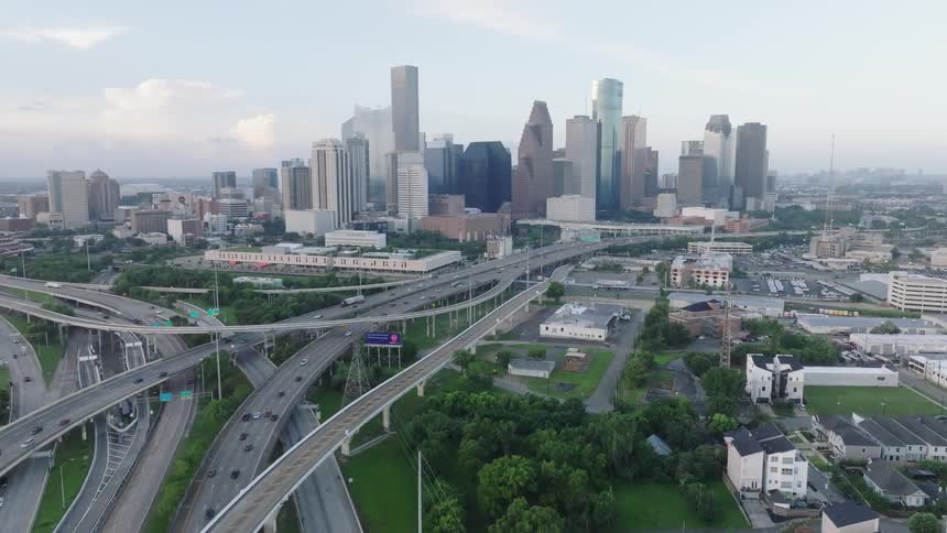 Aerial view of a city skyline with surrounding highways and green areas