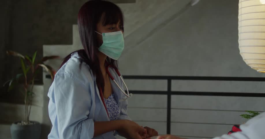 A male patient explains to a female healthcare personnel while lying down in a room during daytime