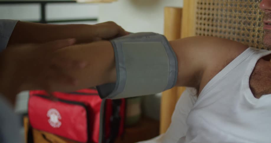 Nurse putting on a blood pressure monitor on a mans arm