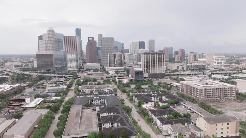 A city skyline view revealing a series of highrises and skyscrapers at midday