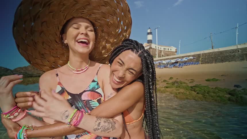 Friends hug and laugh on the beach