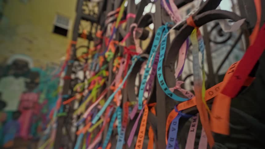 The gate outside the building has ribbons hand on it