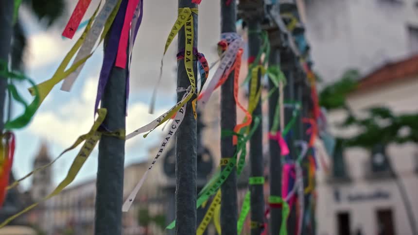 Colorful ribbons tied to metal railing flowing in the breeze
