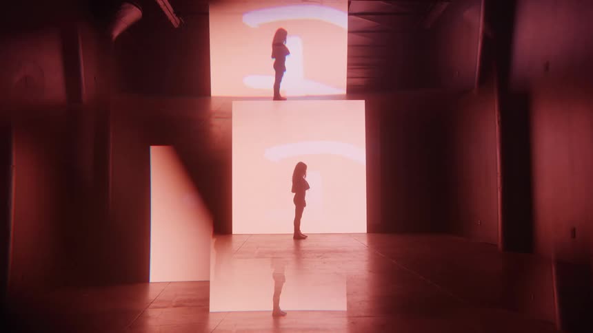 Person standing in front of large illuminated panels