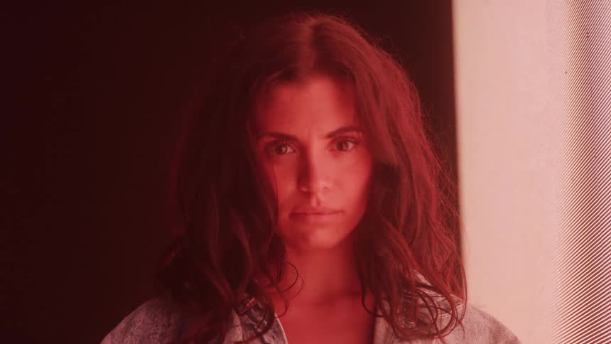 Portrait of a woman next to a screen displaying lights of different colors