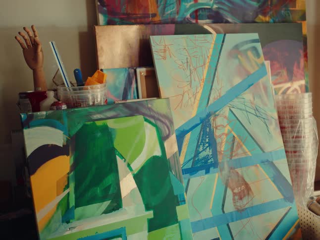 The video shows several paintings in a studio the only text visible is a watermark that says filmsupply across the screen there are no other lines of text to describe