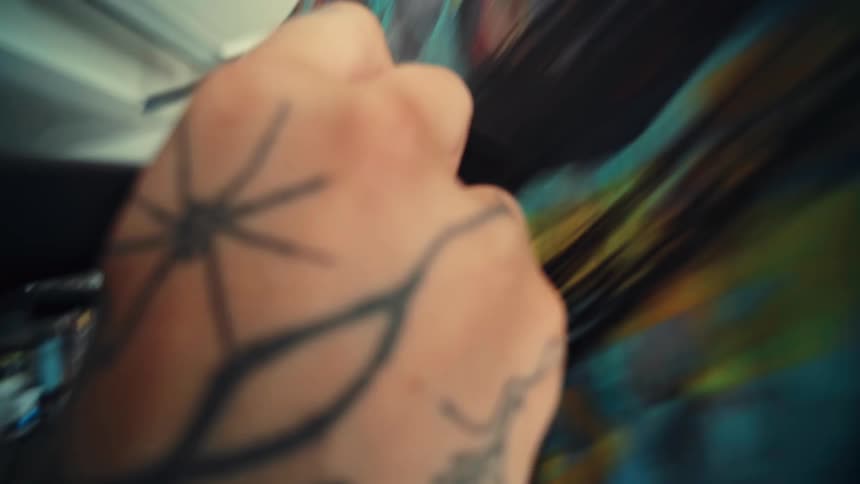 Hand with a brush painting on a canvas