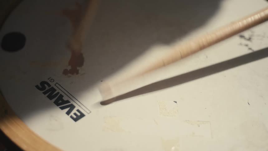 Drumstick on a worn evans drumhead