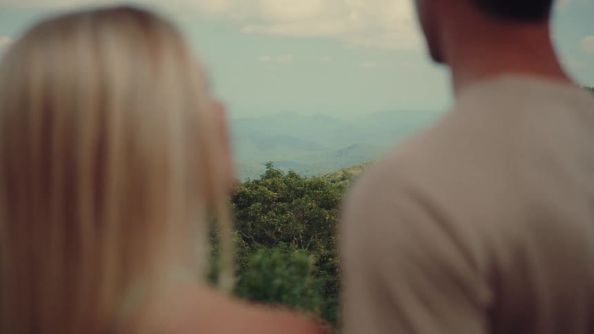 A couple are overlooking a large forest