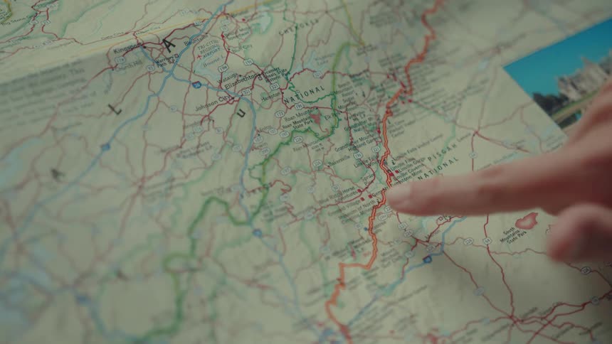 The video shows two lines on a map the first line is a red line that a finger traces representing a path or a road the second line is a green line running parallel to the red line it appears to represent a different route or an alternative path