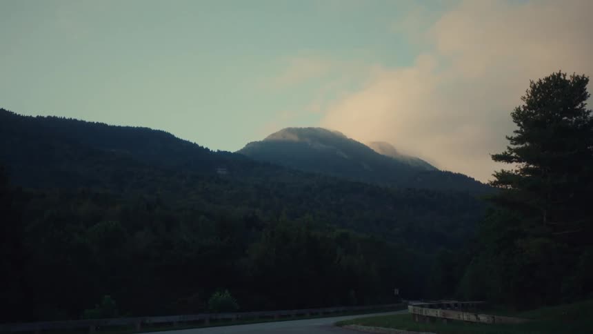 Panoramic view of a mountain top and a forest near the road