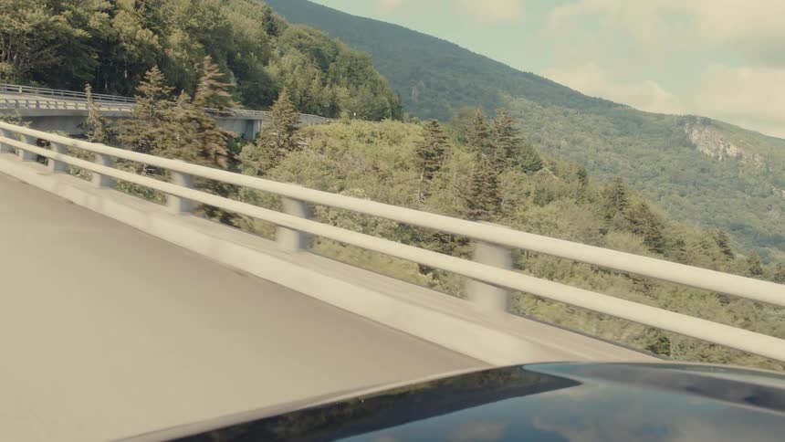 Car traveling down a winding road in the mountains