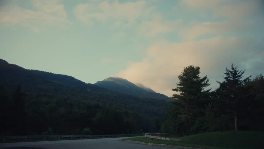 Mountains and trees under a cloudy sky