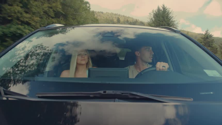 A happy couple is enjoying a scenic road trip together on a sunny day