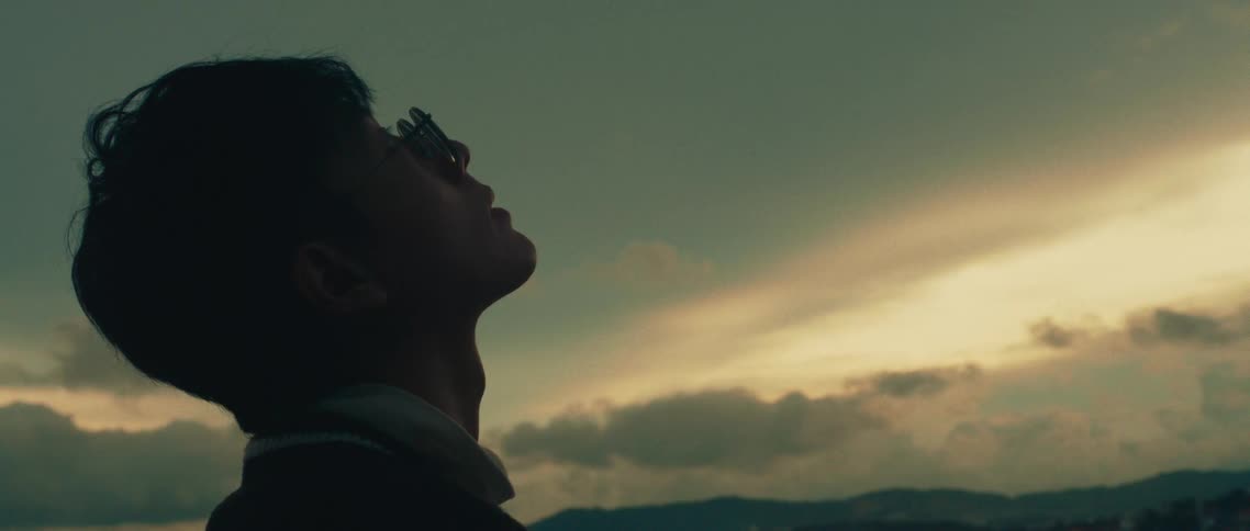 Man wearing glasses looking up on a late afternoon outdoors