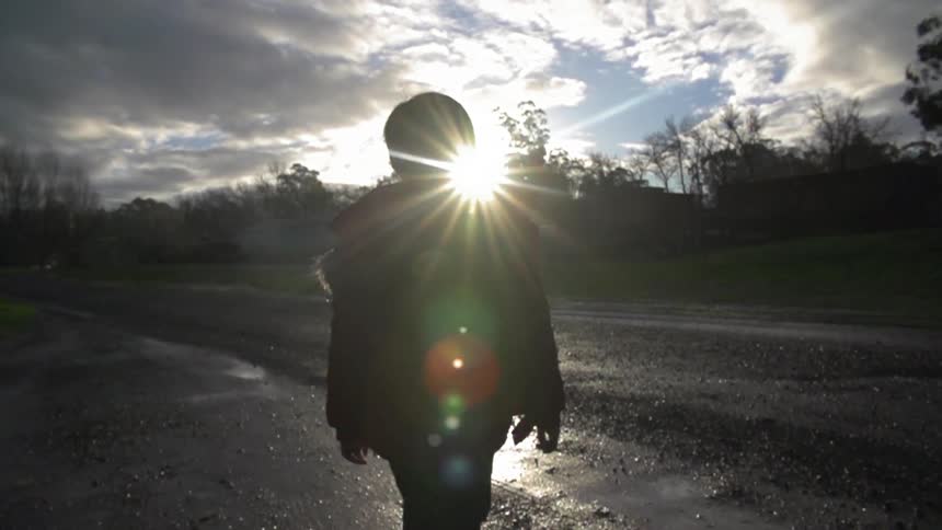 Boy walking outside on a cloudy day