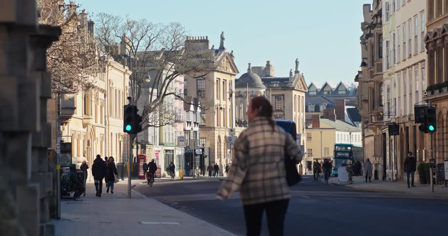 Bus passing on an urban street with pedestrians walking on the sidewalks
