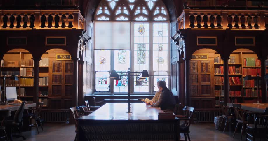 Two men are talking in the library
