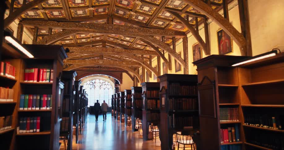 Two men walking down a library hallway