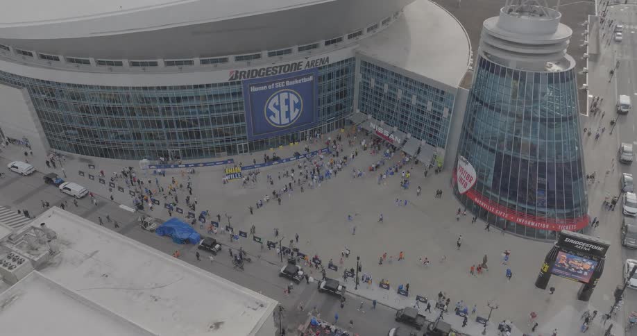 Aerial of a crowded stadium entrance beside a street in metropolitan city during daytime