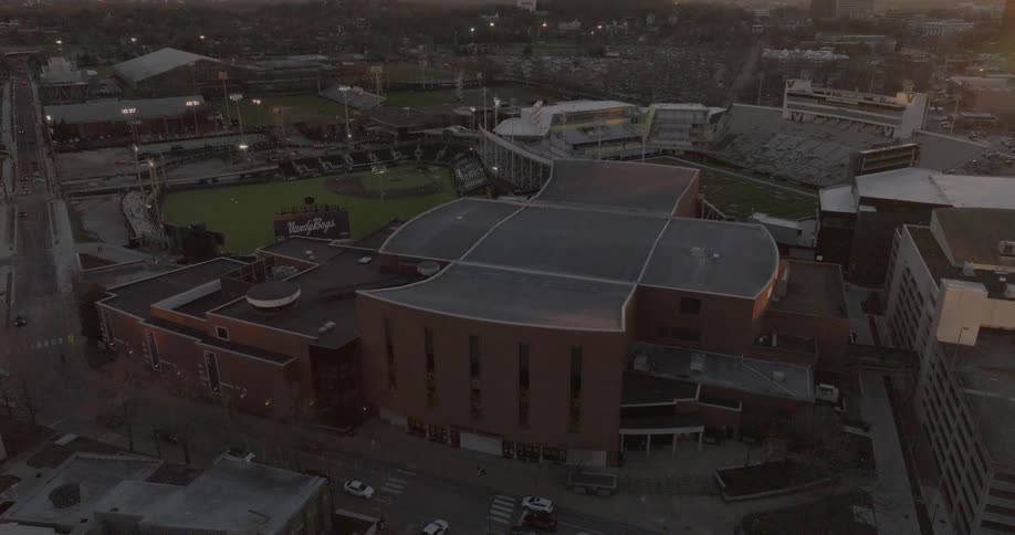 An aerial view of downtown nashville at dusk showcases bridgestone arena the att building and nearby crowds moving through the city streets