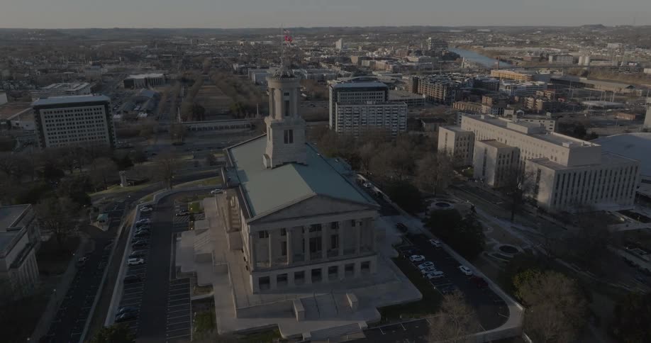 Historic building with central dome and flag on top stands out in the urban landscape