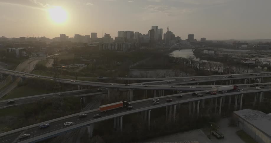 Elevated highway with heavy traffic at sunset against the city skyline
