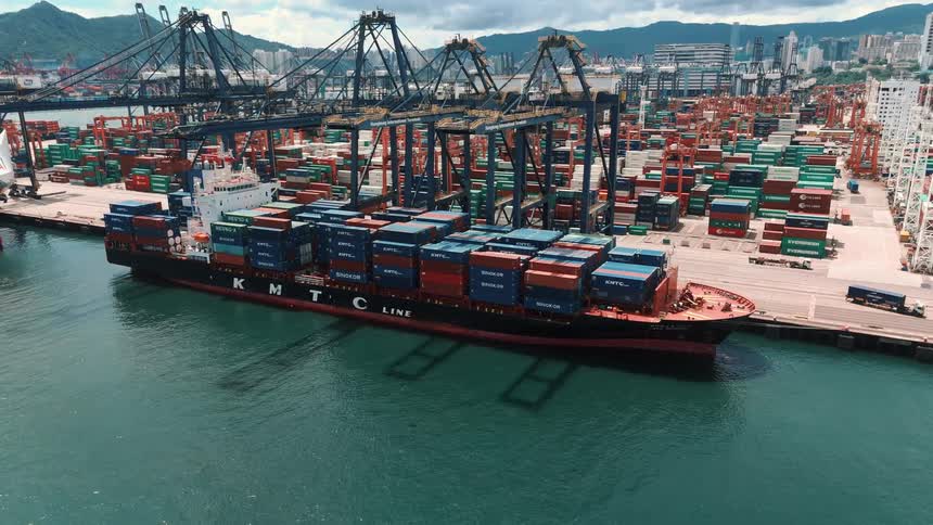 Cargo ship docked being loaded by cranes at the port