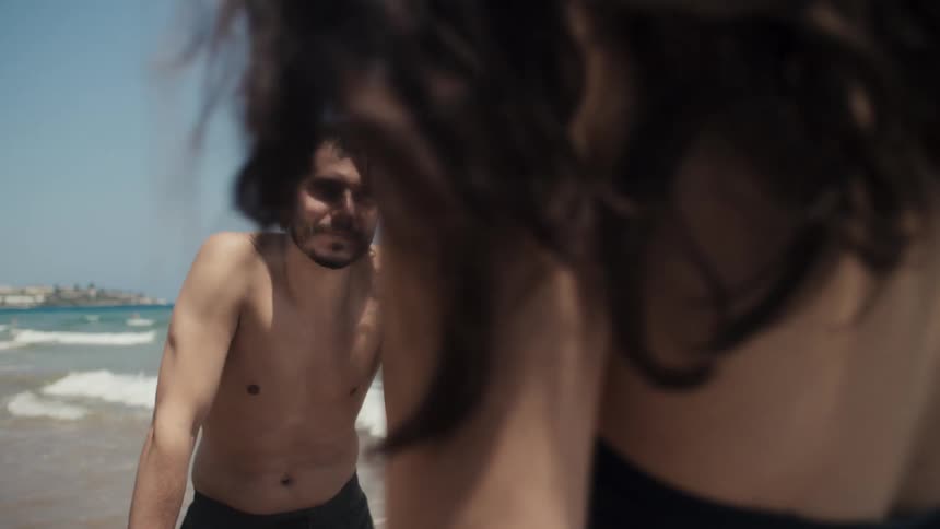 Man and woman at the shoreline leaning on stand up paddle boards
