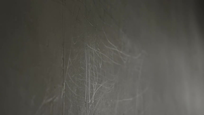 Closeup of a scratched neutral toned wall surface