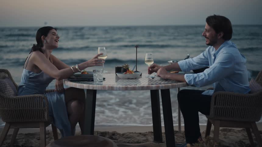 A couple are having dinner on the beach