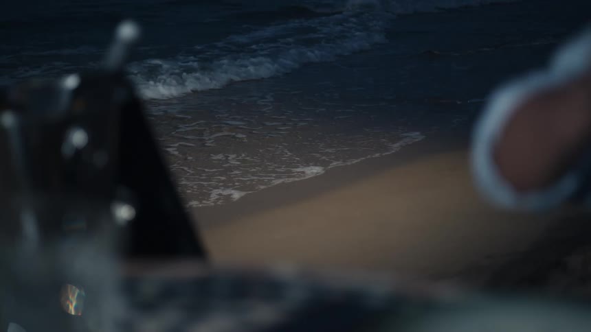 A man drinks wine at a beach