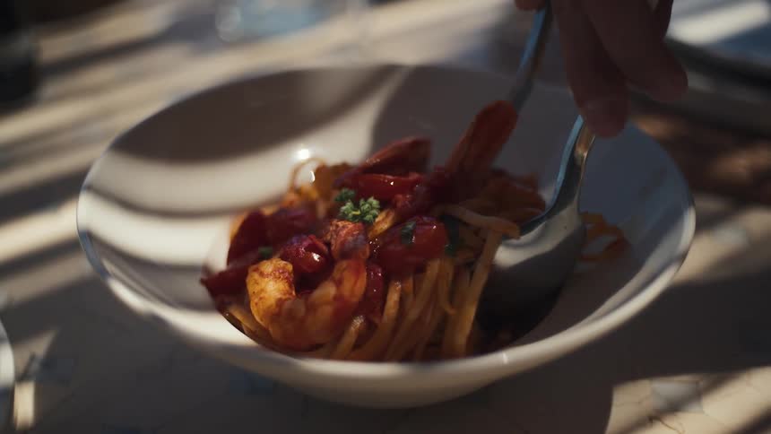 A spoon stirs up a bowl of food