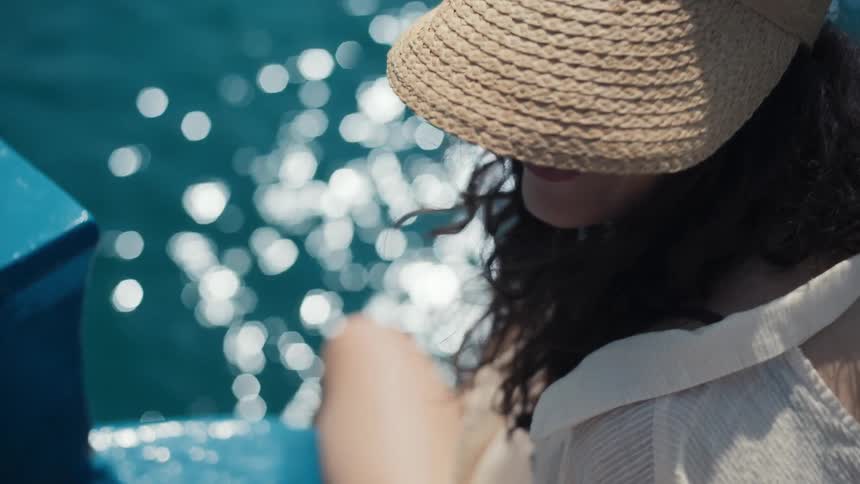 A woman is sitting by the water