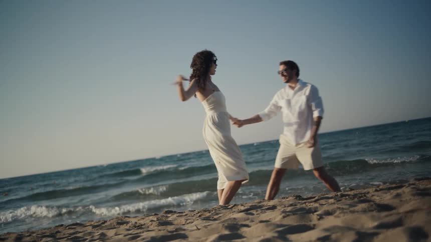 A couple dances on the beach