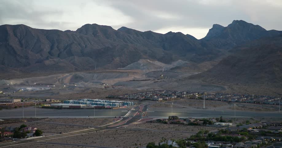 A small town surrounded by mountains with a freeway crossing through it and scattered displaced buildings throughout the area