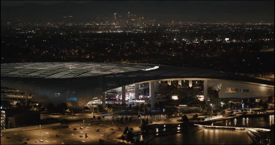 The large sports stadium is brightly lit at night