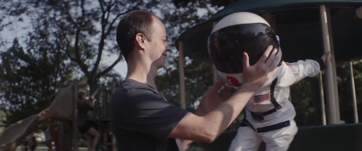 A man puts a space helmet on a girl