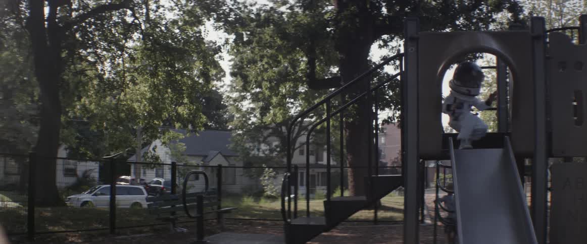 A girl in a space suit plays on a slide
