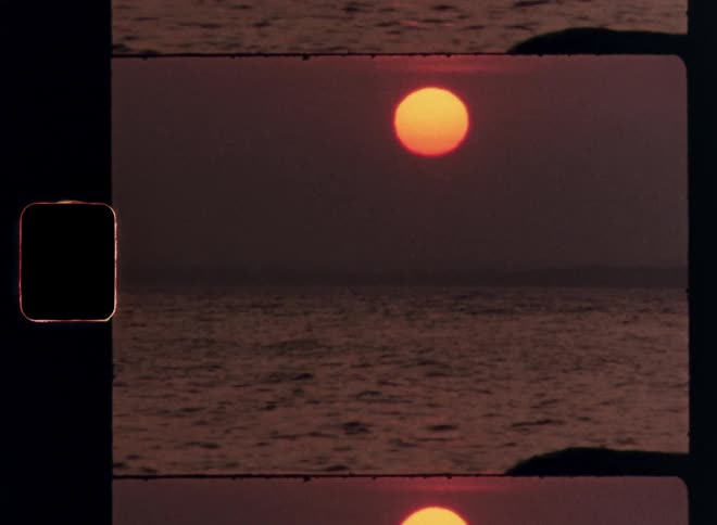 Big yellow sun setting on the horizon over the ocean